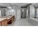 Bright bathroom with a long double sink vanity, standalone tub, glass shower, and neutral tile flooring at 1943 Blue Heron Way, Lawrenceville, GA 30043