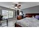 Spacious bedroom featuring wood-look flooring, a ceiling fan, and a large window providing natural light at 1943 Blue Heron Way, Lawrenceville, GA 30043