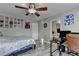 Well-lit bedroom features wood-look floors, ceiling fan, wall decor, and a desk area at 1943 Blue Heron Way, Lawrenceville, GA 30043
