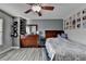 Cozy bedroom with hardwood floors, large dresser, and a ceiling fan. Features wall decor at 1943 Blue Heron Way, Lawrenceville, GA 30043