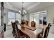 Spacious dining room with elegant chandelier and an adjacent room with glass doors at 1943 Blue Heron Way, Lawrenceville, GA 30043
