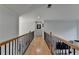Long hallway featuring wooden floors, a black metal and wooden railing, and neutral-toned walls at 1943 Blue Heron Way, Lawrenceville, GA 30043