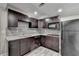Kitchen featuring modern appliances, granite countertops, dark cabinets, and tiled backsplash at 1943 Blue Heron Way, Lawrenceville, GA 30043