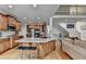 Open kitchen with wood cabinets, island with bar seating, stainless steel appliances, and hardwood floors at 1943 Blue Heron Way, Lawrenceville, GA 30043