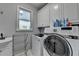Well-equipped laundry room with a modern washer and dryer, sink, and ample storage cabinets at 1943 Blue Heron Way, Lawrenceville, GA 30043