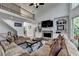 Open-concept living room with a stone fireplace, built-in shelves and adjacent staircase to an upper level at 1943 Blue Heron Way, Lawrenceville, GA 30043