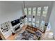 High-angle view of living room with tall windows, fireplace, and view of the lake beyond at 1943 Blue Heron Way, Lawrenceville, GA 30043