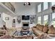 Living room with a stone fireplace, built-in shelving, and large bright windows at 1943 Blue Heron Way, Lawrenceville, GA 30043