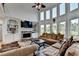 Bright living room with stone fireplace, built-in shelving, and large windows with outdoor views at 1943 Blue Heron Way, Lawrenceville, GA 30043