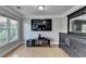 Main bedroom with wood floors, a large television, and a dresser, plus large windows overlooking a wooded area at 1943 Blue Heron Way, Lawrenceville, GA 30043