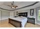 Spacious bedroom with tray ceiling, hardwood floors, and a large bed with a decorative headboard at 1943 Blue Heron Way, Lawrenceville, GA 30043