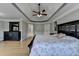 Spacious bedroom with tray ceiling, hardwood floors, large bed and dark furniture with decoration elements at 1943 Blue Heron Way, Lawrenceville, GA 30043