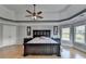 Spacious bedroom with tray ceiling, hardwood floors, large bed and dark furniture with decoration elements at 1943 Blue Heron Way, Lawrenceville, GA 30043