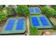 Aerial view of well-maintained blue and green tennis courts surrounded by mature trees at 1943 Blue Heron Way, Lawrenceville, GA 30043