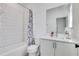 Well-lit bathroom featuring a shower with tub, black and white curtain, and white vanity at 230 New St # 1303, Decatur, GA 30030