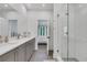 Bright bathroom with a glass shower door, double vanity and a view to the bedroom at 230 New St # 1303, Decatur, GA 30030
