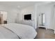 Bright bedroom featuring hardwood floors, TV on a white dresser, and a decorative mirror at 230 New St # 1303, Decatur, GA 30030