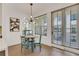 Bright dining area featuring an elegant chandelier, round table, and large windows with blinds at 230 New St # 1303, Decatur, GA 30030