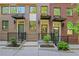 A row of brick townhomes featuring covered entries, modern black awnings, and well-maintained landscaping at 230 New St # 1303, Decatur, GA 30030
