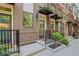 Brick townhome featuring a charming front entry with black awnings, small garden bed and black iron railing at 230 New St # 1303, Decatur, GA 30030