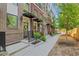 Brick townhomes line a street with sidewalks and young trees planted along the curb at 230 New St # 1303, Decatur, GA 30030