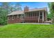 View of a cozy home backyard featuring a screened porch and lush green lawn at 3492 Ember St, Marietta, GA 30066