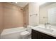 Well-lit bathroom featuring a tub with tile surround, modern fixtures, and dark wood vanity with stone countertop at 3492 Ember St, Marietta, GA 30066