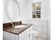 Bathroom with white tile, granite counters, oval mirror, and a window at 4781 Brownsville Rd, Powder Springs, GA 30127