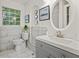 Stylish bathroom with marble tiling, updated vanity, and a decorative round mirror at 4781 Brownsville Rd, Powder Springs, GA 30127