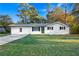 Charming single-story home with a well-manicured lawn, white painted brick, and black shutters at 4781 Brownsville Rd, Powder Springs, GA 30127