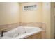 Bathroom with a jetted bathtub and marble tile surround at 6134 Silver Spur Dr, Lithonia, GA 30058