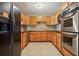 A kitchen with stainless steel appliances, light wood cabinets and tile flooring at 6134 Silver Spur Dr, Lithonia, GA 30058