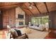 Living room boasts vaulted wood ceilings, a stone fireplace, and large windows with natural light at 6134 Silver Spur Dr, Lithonia, GA 30058