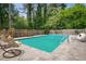 Backyard pool with mature trees and shrubs along fence line at 6134 Silver Spur Dr, Lithonia, GA 30058