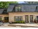 Charming two-story brick townhome featuring black roof, beautiful windows, and well-maintained landscaping at 104 Verlaine Nw Pl, Atlanta, GA 30327