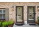 Close-up of charming townhome front door with brick entryway and tasteful landscaping at 104 Verlaine Nw Pl, Atlanta, GA 30327
