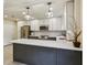 Bright kitchen features stainless steel appliances, white cabinets, pendant lights and island seating at 104 Verlaine Nw Pl, Atlanta, GA 30327