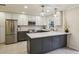Bright kitchen features stainless steel appliances, white cabinets, pendant lights and quartz countertops at 104 Verlaine Nw Pl, Atlanta, GA 30327