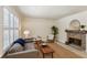 Cozy living room featuring large windows, neutral colors, a fireplace, and hardwood floors at 104 Verlaine Nw Pl, Atlanta, GA 30327