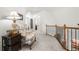 Hallway with a floral arm chair, iron railing, and white walls offering a bright, airy, and transitional space at 112 Pebblebrooke Run, Canton, GA 30115
