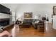 Bright living room featuring a stone fireplace, hardwood floors, and comfortable seating at 112 Pebblebrooke Run, Canton, GA 30115