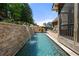 A luxurious pool with stone wall and a relaxing patio area, perfect for outdoor entertainment and enjoyment at 112 Pebblebrooke Run, Canton, GA 30115
