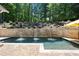 Backyard pool featuring a brick water feature and mature trees at 112 Pebblebrooke Run, Canton, GA 30115
