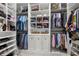 Spacious walk-in closet featuring custom shelving, ample hanging space, and built-in storage cabinets for organization at 112 Pebblebrooke Run, Canton, GA 30115