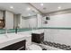 Modern bathroom with double sinks, large mirror, tiled walls, and shower with glass partition and decorative floor tiles at 130 26Th St # 706, Atlanta, GA 30309