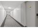 Long hallway with carpet, white walls and ceiling leading to a door with the number 708 at 130 26Th St # 706, Atlanta, GA 30309