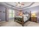 Bedroom featuring stylish, lavender walls, tray ceiling, carpet and a decorative metal bed frame at 4891 Tarry Post Ln, Suwanee, GA 30024
