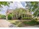 Charming two-story brick home boasts a manicured lawn and a welcoming covered front porch at 4891 Tarry Post Ln, Suwanee, GA 30024