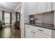 Charming kitchenette featuring white cabinets, granite countertops, and a convenient coffee station at 4891 Tarry Post Ln, Suwanee, GA 30024