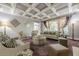 Elegant living room featuring a coffered ceiling, stylish furniture, and large windows for natural light at 4891 Tarry Post Ln, Suwanee, GA 30024